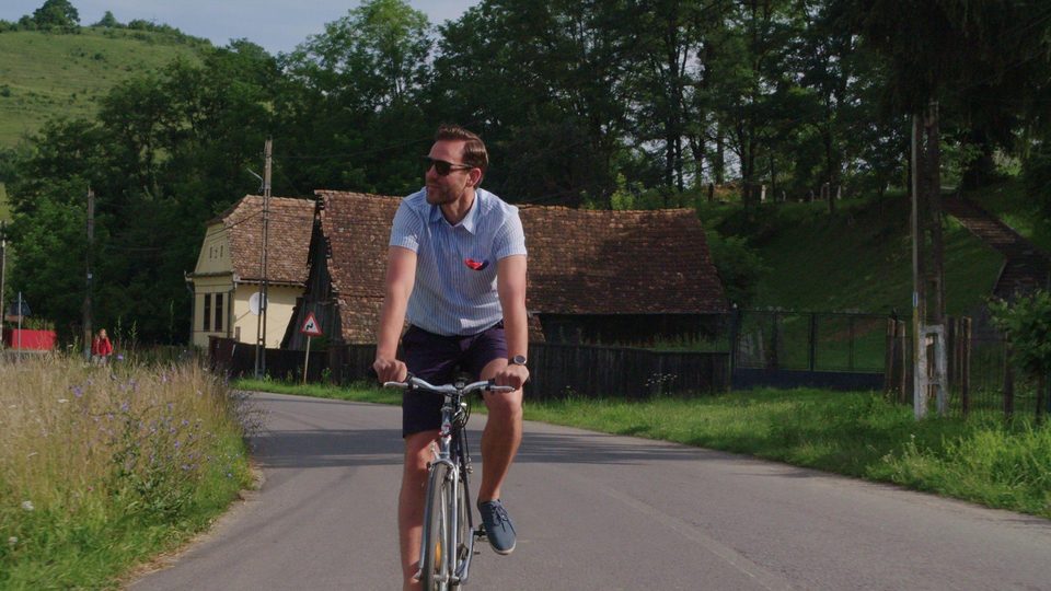 Robert Marshall on a bicycle in a Transylvanian village